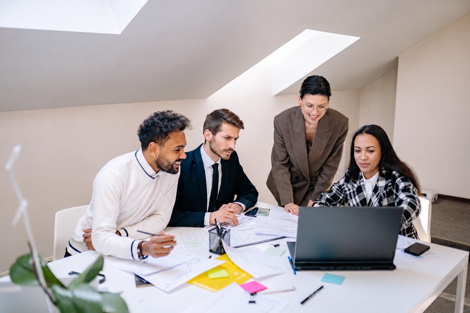 Colleagues meeting around a laptop in an office