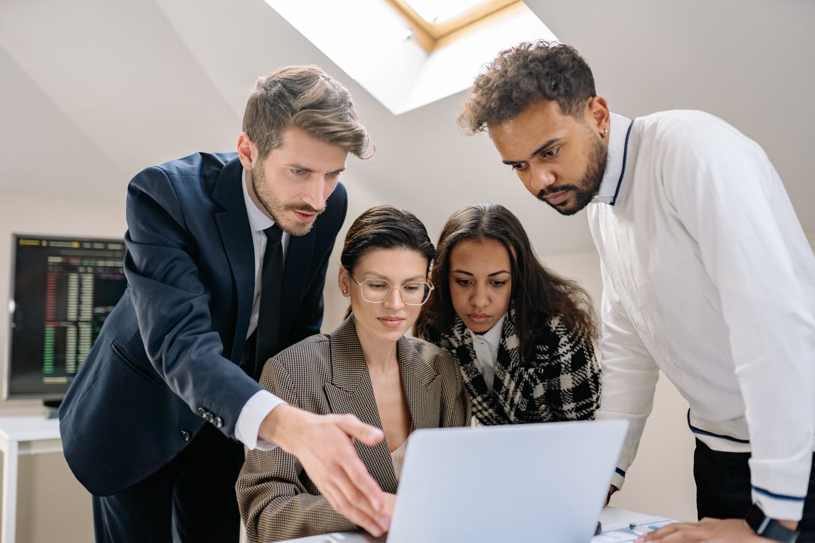 A team reviewing a project together on a laptop in an office
